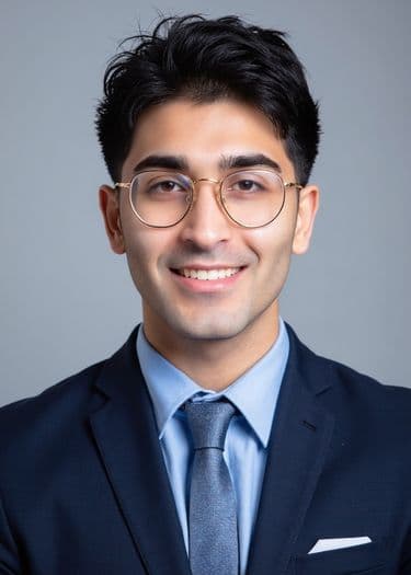 Professional headshot of a man in glasses, blue shirt, and suit, ERAS photo example