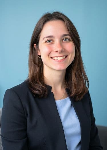 Professional headshot of a woman smiling in a blazer and light-blue blouse, ERAS photo example